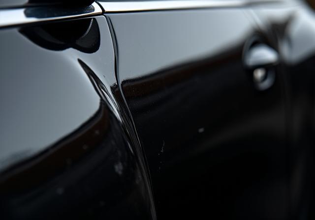 The same car paint now a flawless, deep black mirror finish.